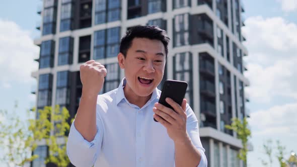 Lucky Happy Euphoric Asian Business Man Wearing Shirt Celebrate Mobile Win