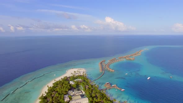 Aerial view of island with a luxury bungalow resort, Maldives.