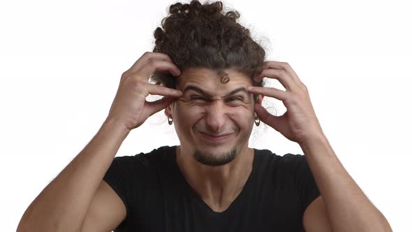 Closeup of Tensed Young Caucasian Man with Curly Hair and Beard Standing in Black Tshirt Shaking