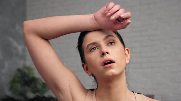 Sportive Strong Woman Wiping Sweat From Face After Intense Workout Exercise