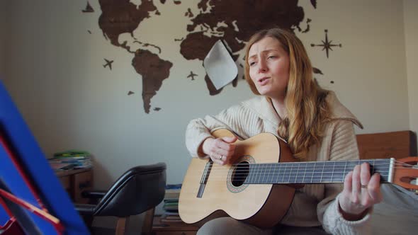 Woman Playing Guitar And Singing