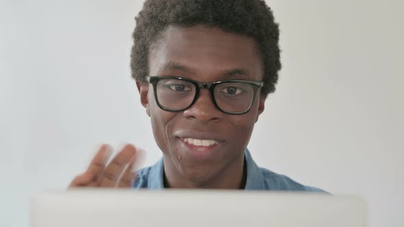 Close Up of Young African Man Talking on Video Call on Laptop in Office