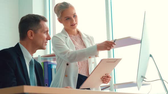 Two Business People Talk Project Strategy at Office