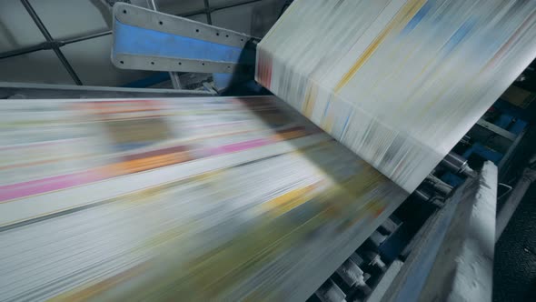 Printing Press with Uncut Magazine Pages Going Through It