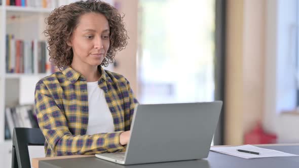 Attractive Young Mixed Race Woman with Laptop Pointing at Camera