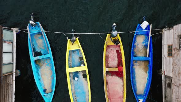 Top view of fishermen huts with moored boats.