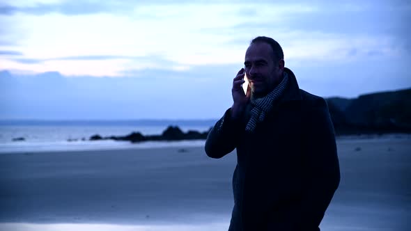 Man at beach talking on mobile phone