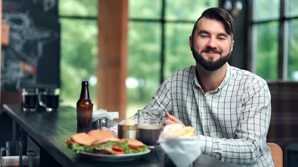 Portrait Handsome Smiling Young Man Posing Bar Counter Enjoying Beer Fast Food Medium Shot