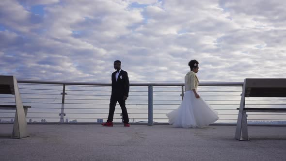 African American Bride and Groom in Dress and Suit Turning and Walking Away to Different Directions