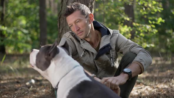 Smiling Caucasian Man Looking at Dog Walking Away in Slow Motion in Forest
