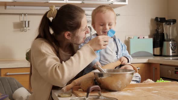 Happy Smiling Mother Playing and Having Fun with Her Little Baby Son While Making Dough and Baking