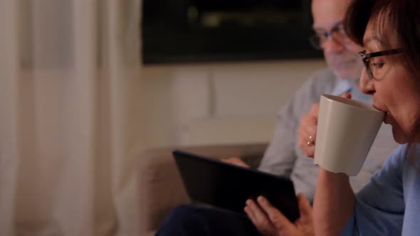 Senior Couple with Book and Tablet Pc at Home