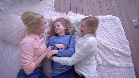 Happy Childhood, Laughing Mum with Children Girls Lie on Bed and Communicate with Each Other