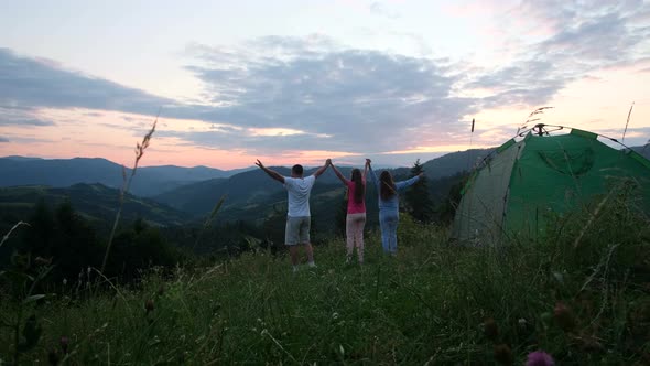 Friends Have Fun Near the Tent in the Mountains