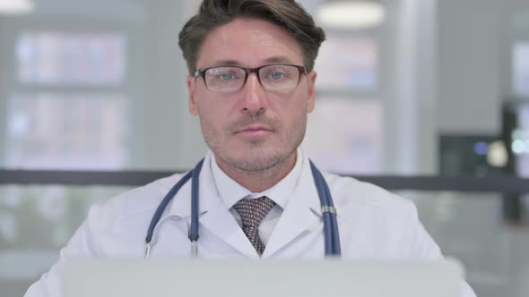 Close Up of Doctor with Laptop Looking at Camera