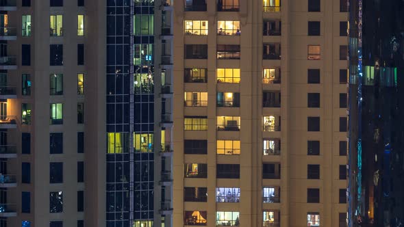 Glowing Windows in Multistory Modern Glass and Metal Residential Building Light Up at Night