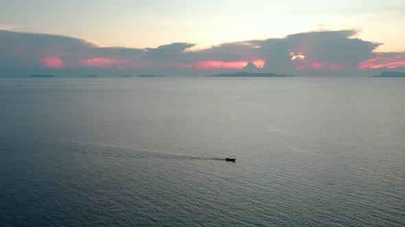 Small boat cruising along the coast of Nathon, Koh Samui Thailand. Angthong in background