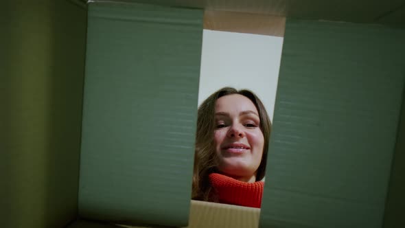 Young Woman Carefully Opens Box Delivery From Online Store