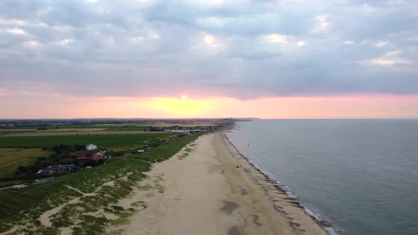 Aerial drone shot flying backwards over a beautiful empty beach in England