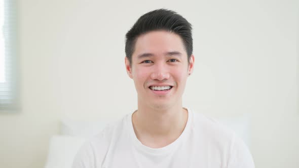 Portrait of Asian young handsome male in pajamas smile and looking at camera