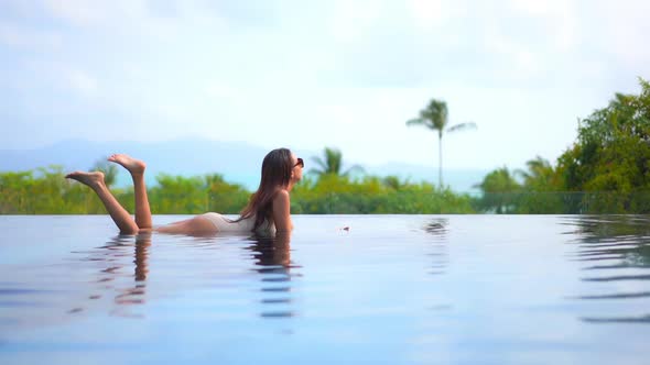 Young asian woman enjoy around outdoor swimming pool for leisure