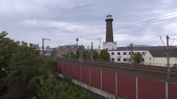 A commuter train on the way to Aachen in Cologne Ehrenfeld on a cloudy day in front of the panorama