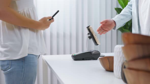 Close up young woman's hand use mobile phone pay for vase goods order.