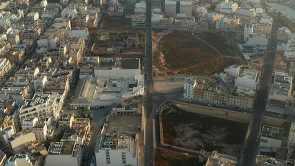 Road Going Through City on Malta Island with Little Car Traffic and with Beige Brown Buildings