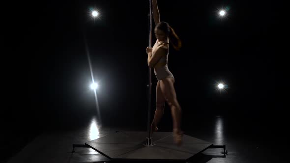 Pole Dance Girl Spinning on a Pole. Black Background