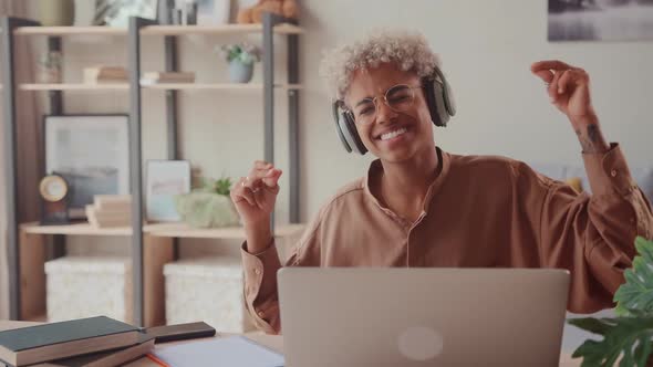 Happy African Lady with Wireless Headphones Listening Music Distracted From Work