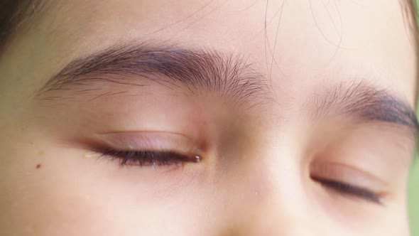 Closeup of the Brown Eyes of the Girl with a Tear Due to Contact Lenses