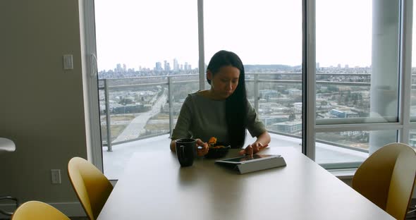 Woman using digital tablet while having breakfast 4k