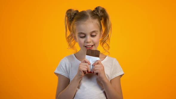 Happy Smiling Preteen Girl Eating Delicious Chocolate, Enjoying Sweet Taste