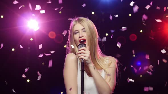 Blonde Girl Singing Into a Retro Microphone Strobe Lighting Effect