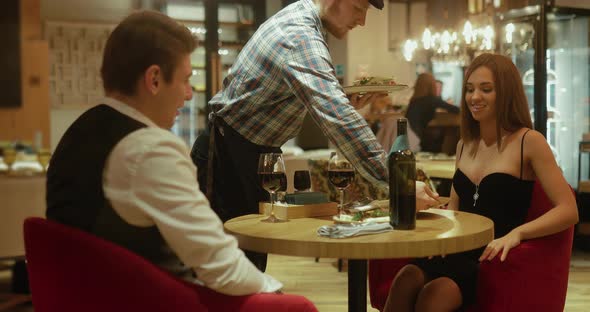 Guy the Waiter Carries Plates of Food Customer Service of a Cozy Restaurant