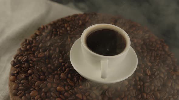 Cup of Coffee and Saucer on Coffee Beans with Dissipating Steam