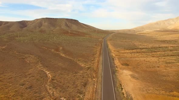 Aerial view of an empty road in dryland of Fuerteventura.