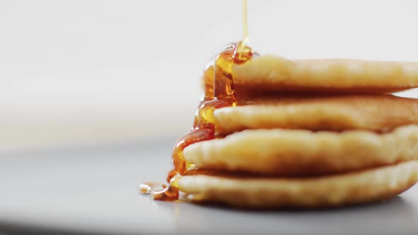 Video of pancakes with maple syrup on white plate seeing from above