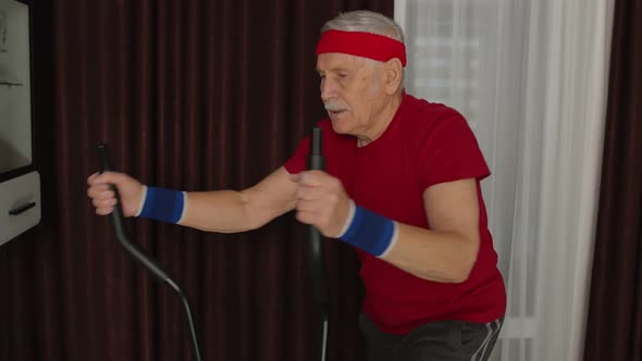 Senior Man in Sportswear Using Orbitrek in Living Room Doing Sport Training Cardio Exercises at Home