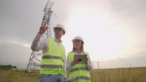 Engineer and Supervisor with Tablet PC and the Drawings are About Lines and Transmission Towers and