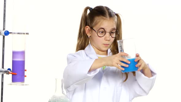 Cute Girl with Ponytails in Uniform and Round Glasses Evaluates Chemical Experiments on White
