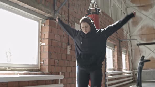 Woman Stretching Arms in Boxing Gym