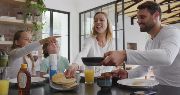 Family having food at dining table in kitchen at comfortable home 4k