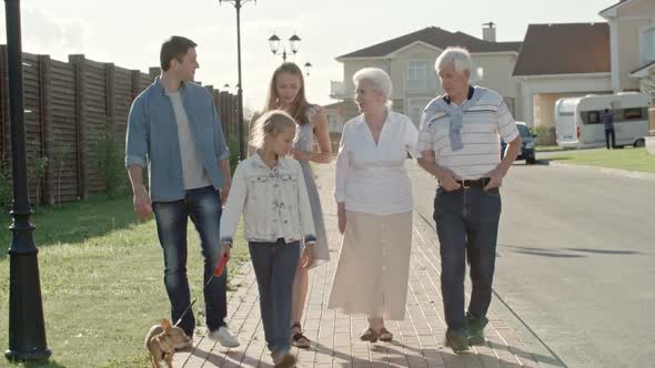 Young Family and Elderly Couple Walking in Countryside