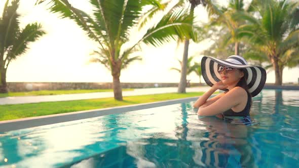 Young asian woman enjoy around outdoor swimming pool for leisure