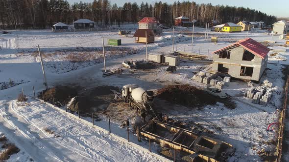 A concrete mixer truck unloads concrete into the foundation. 16