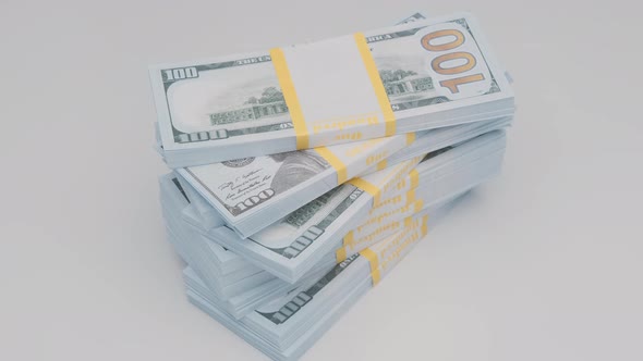 stack of bank bundles with dollars rotating on white background