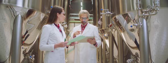 Food engineers taking notes in a factory