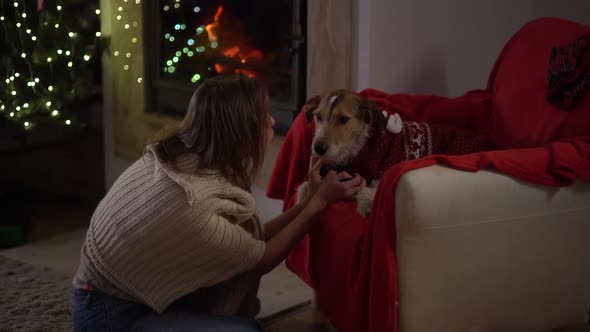 Portraite of Lovely Lonely Woman Sits Alone in a Chair By the Fireplace and Christmas Tree Hugging