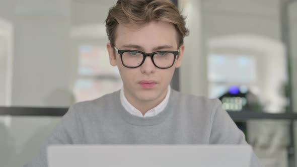 Close Up of Young Man Coughing While Working on Laptop